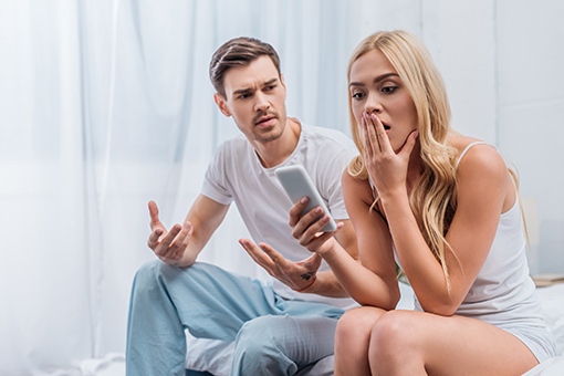 Wife Looking at Husband's Phone She Caught Cheating In Need of Christian Adultery Counseling