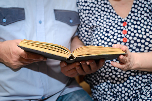 Christian Couple Reading Bible Together After Attending Online Counseling