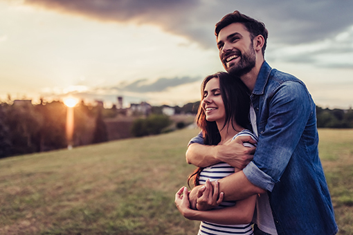 Husband Hugging Wife From Behind During Sunset After Completing Online Christian Marriage Counseling